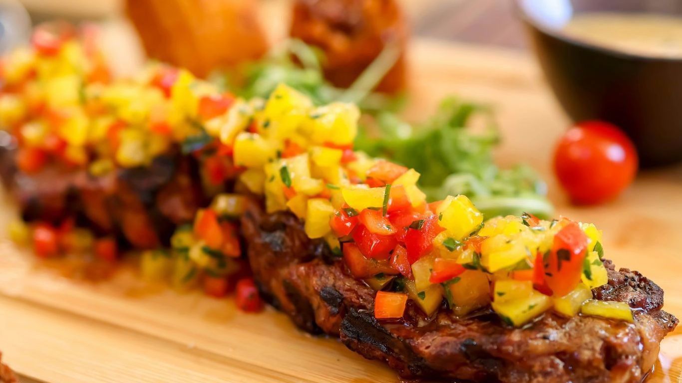 Image of grilled steak with a mango salsa on top.