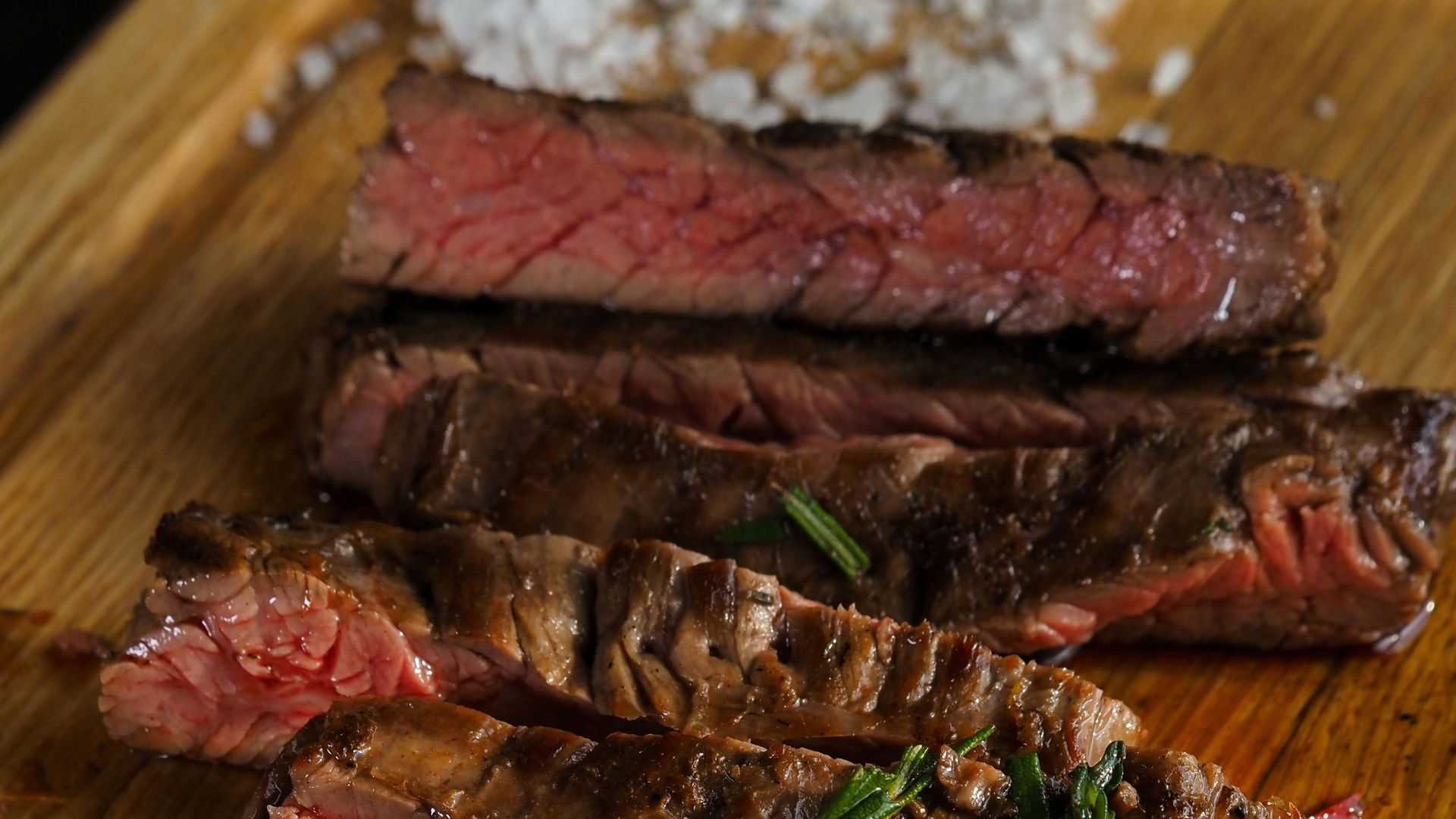 Picture of medium rare steak with sea salt for seasoning.