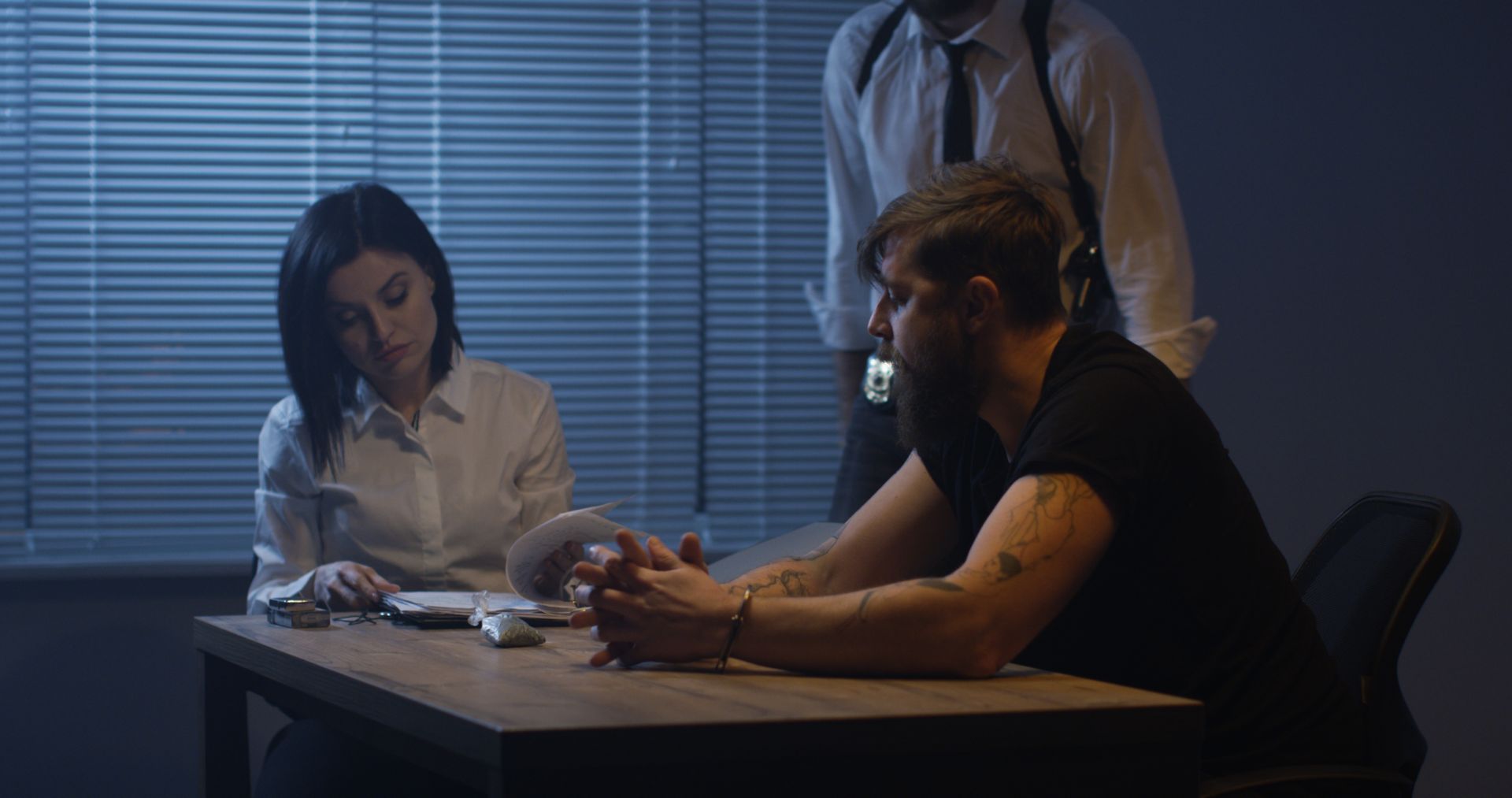 Un uomo e una donna sono seduti a un tavolo in una stazione di polizia.