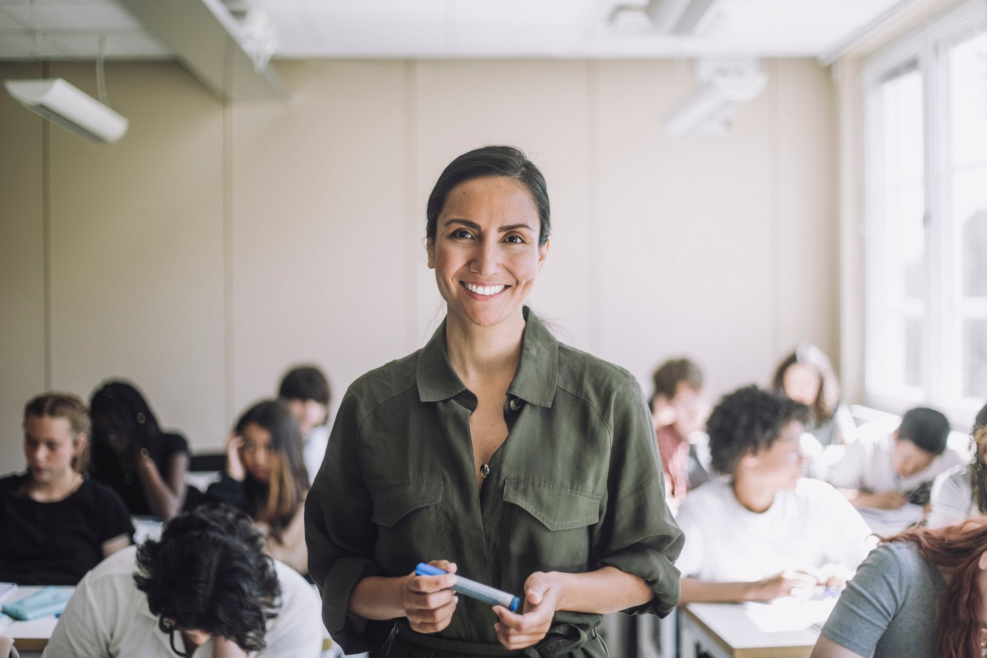 Una donna è in piedi davanti a un'aula piena di studenti.