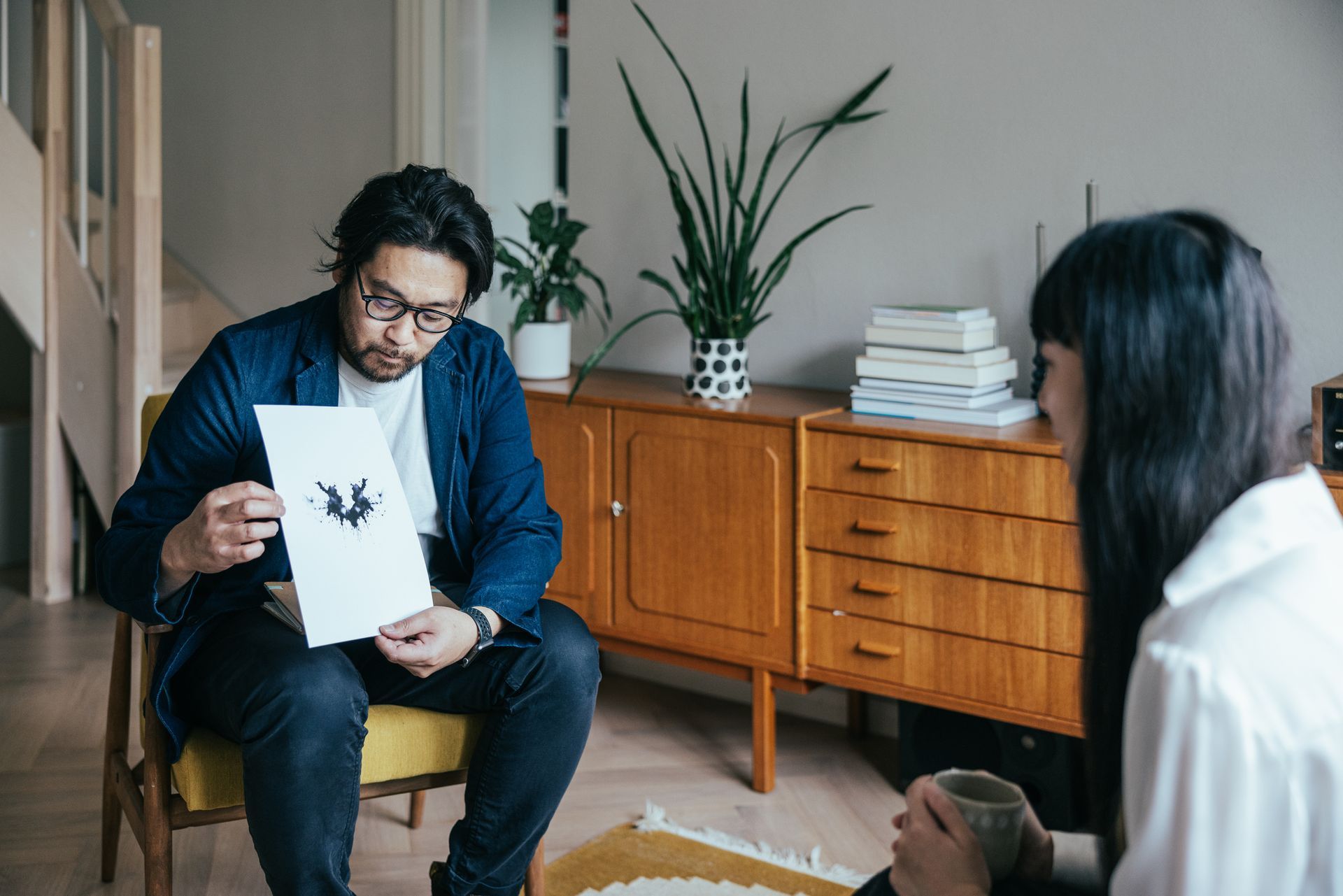 Un uomo e una donna sono seduti in un soggiorno e guardano una macchia di Roschart