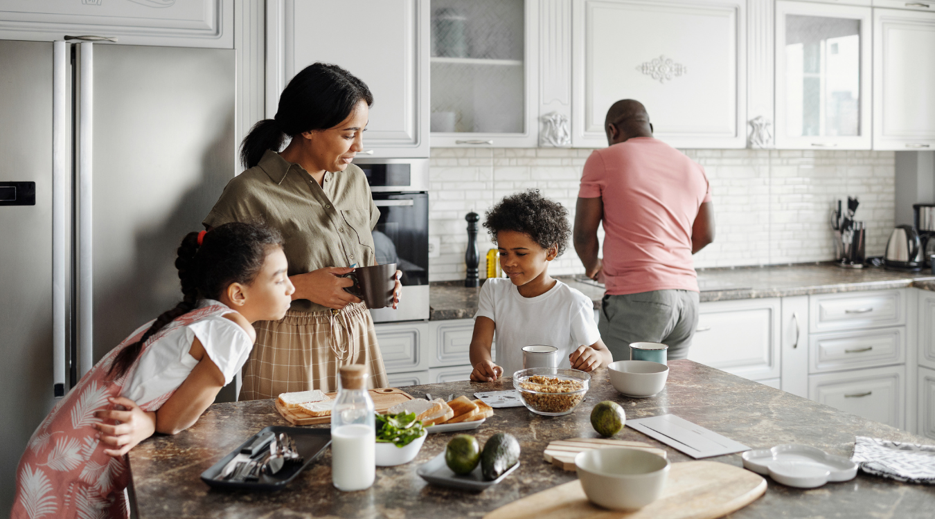 Family cooking in luxury design kitchen around grand marble island Family cooking in luxury design kitchen