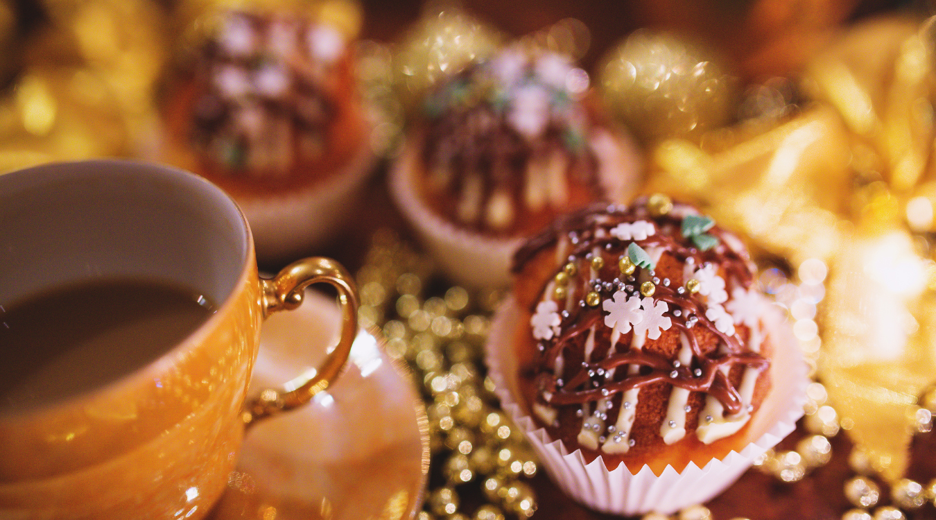 Coffee and Christmas Cake surrounded by decor Cup of coffee next to a cake for Christmas
