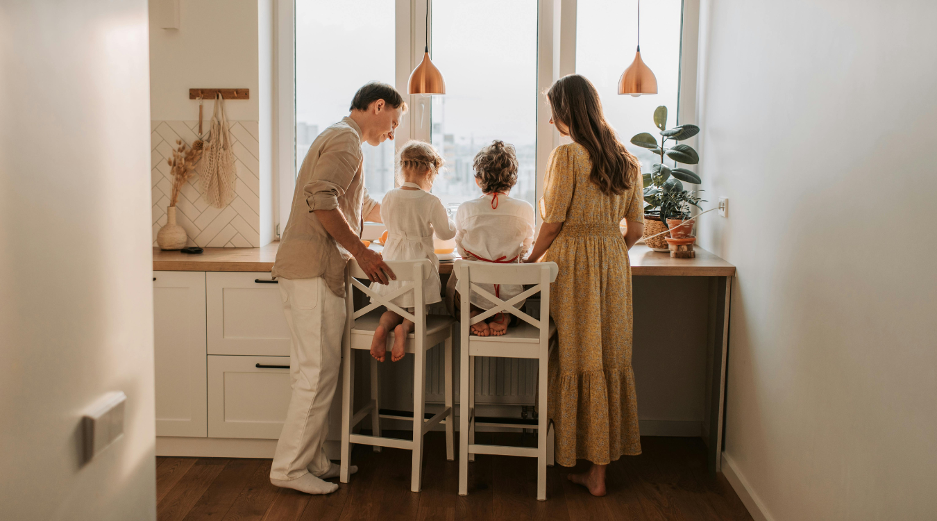 Family in luxury kitchen looking out of the window Family in luxury kitchen