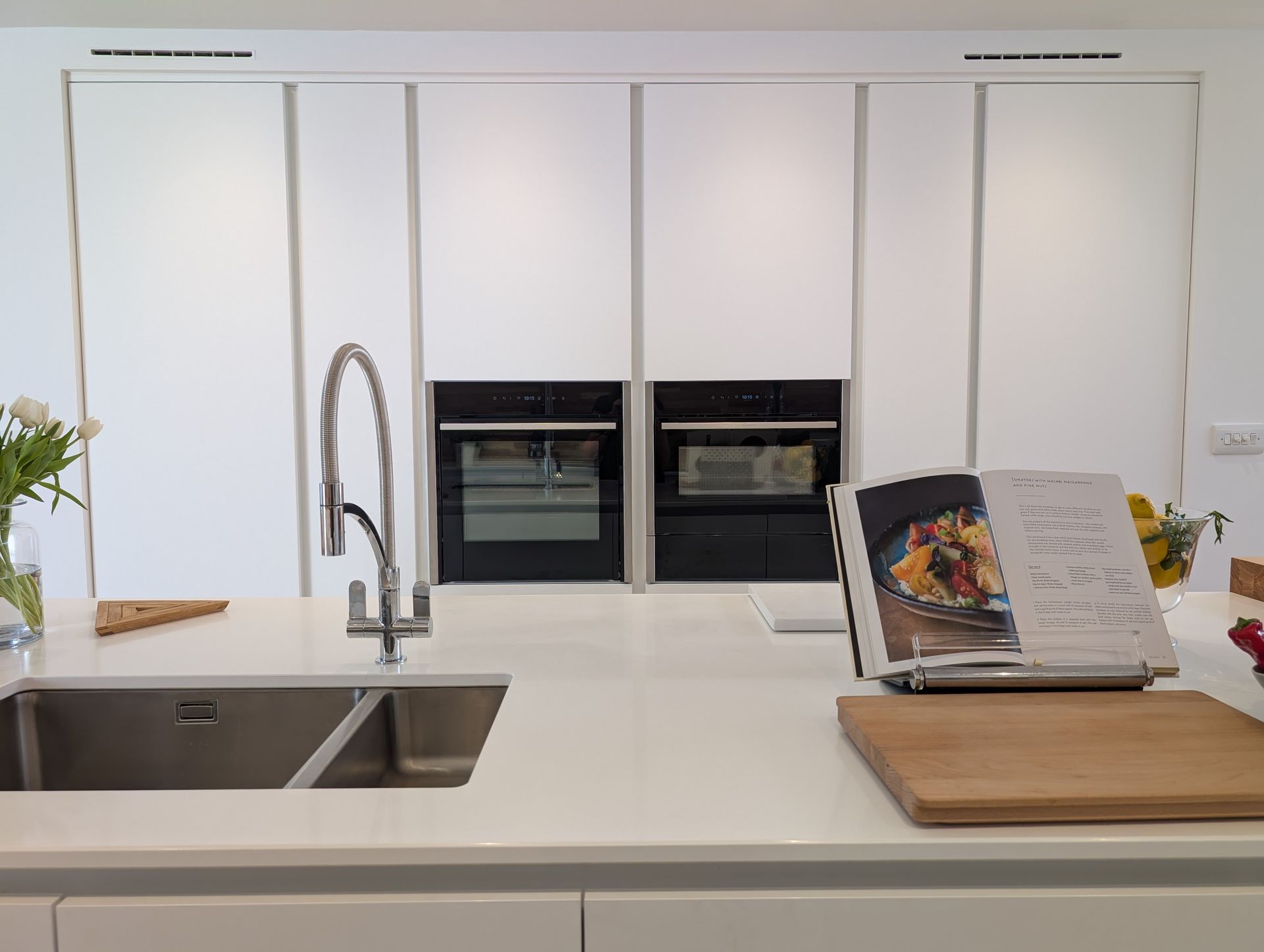 Elegant and bright kitchen design by James James Kitchens with white interior and beautiful storage 
