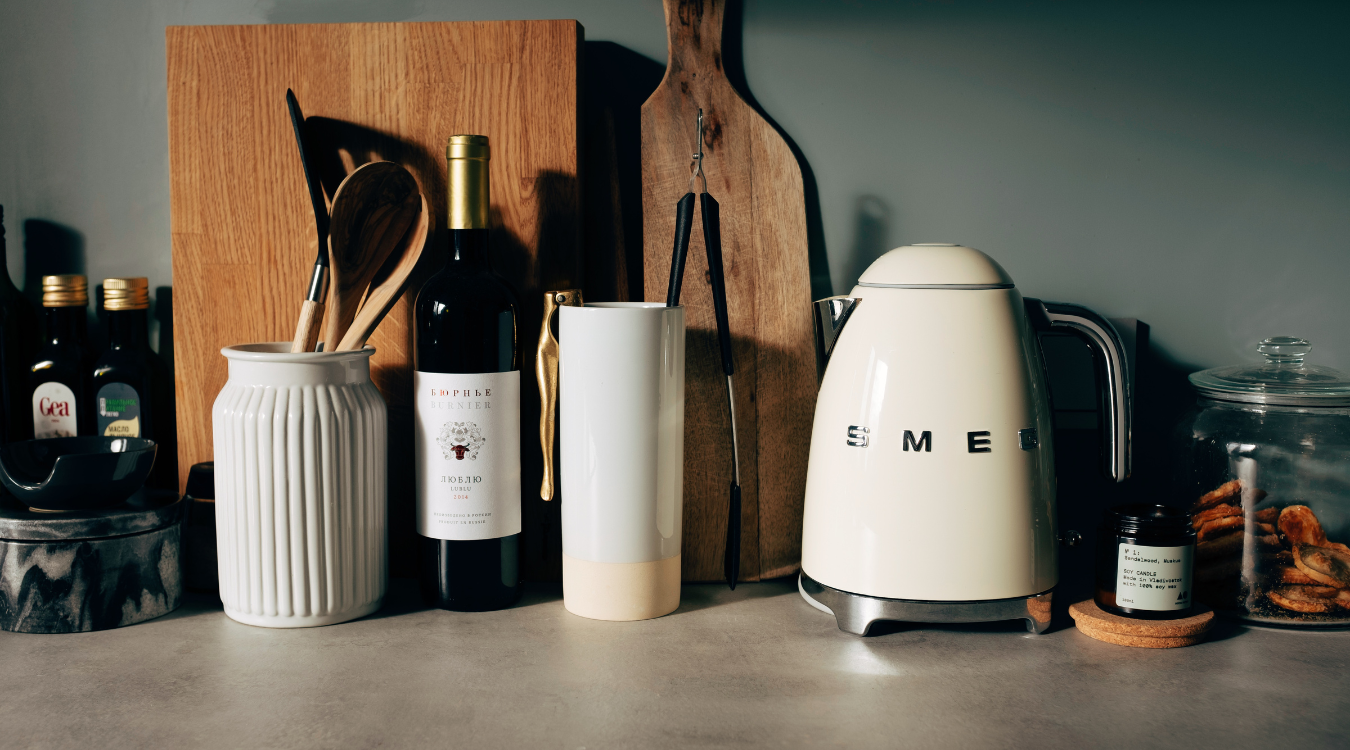 A contemporary kitchen with blue cabinets, a stainless steel fridge, white brick walls, and a coordinating island.