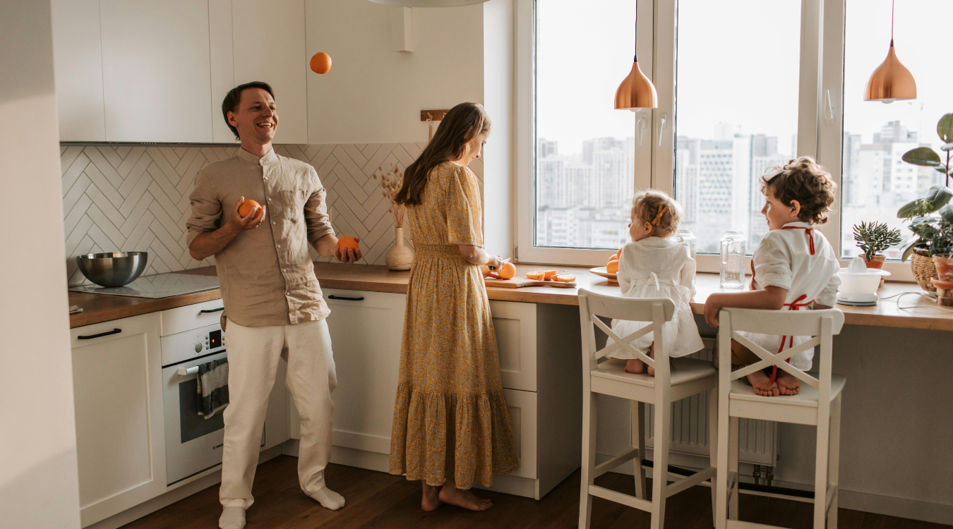 Family of four gathered in a bright, luxury design kitchen with stylish lights
