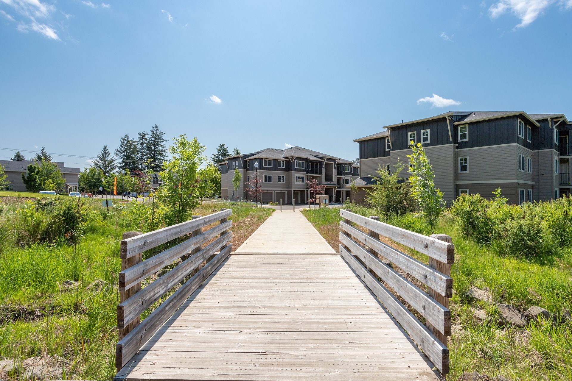 There is a wooden bridge leading to a building in the background.