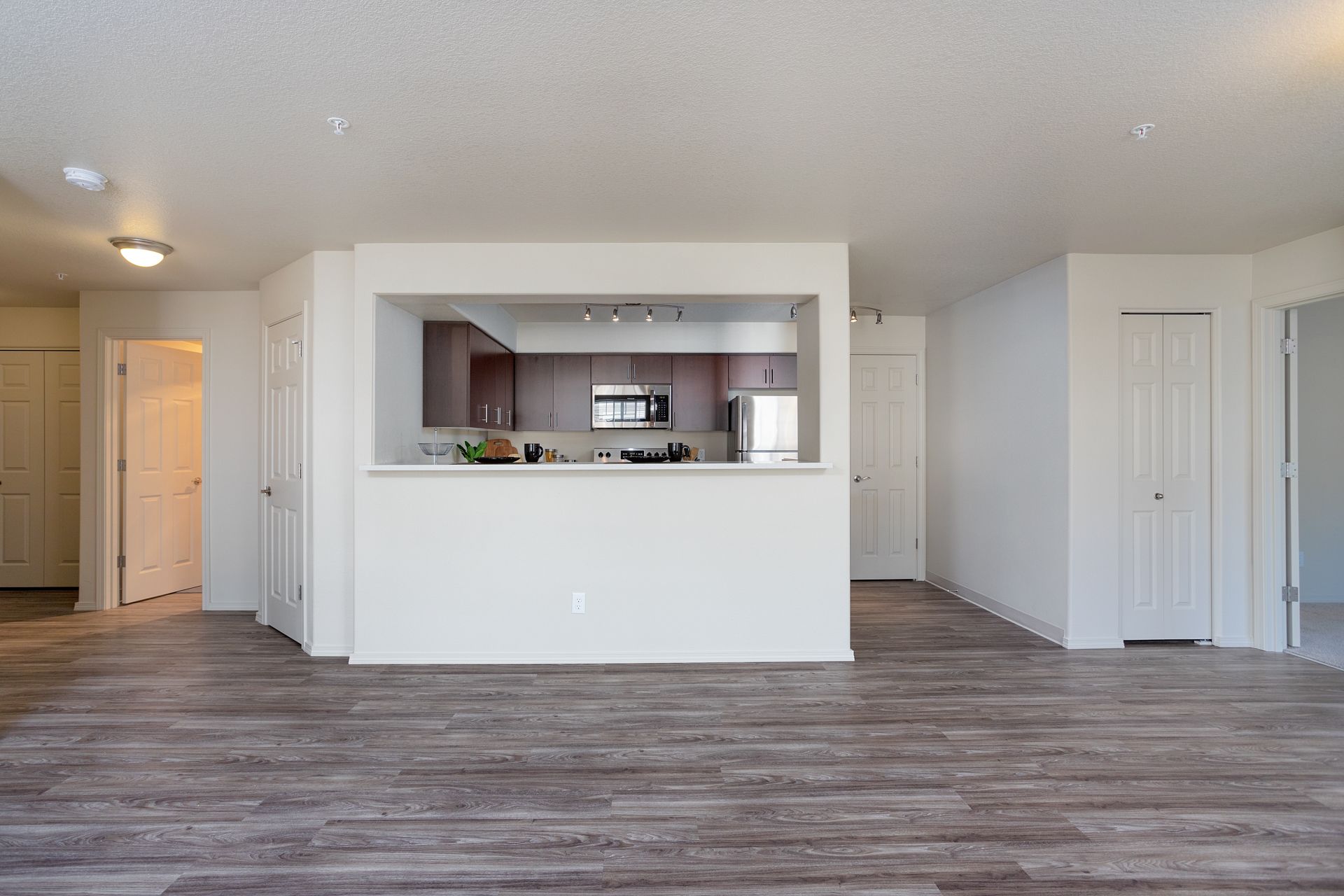 An empty apartment with hardwood floors and a kitchen