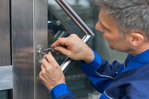 Commercial Locksmith — Male Lockpicker Fixing Door in Sparks, NV
