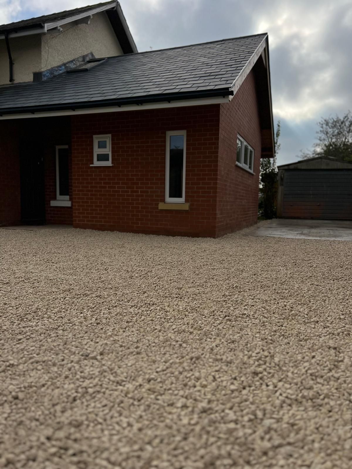 Brick building with gravel driveway and small windows.