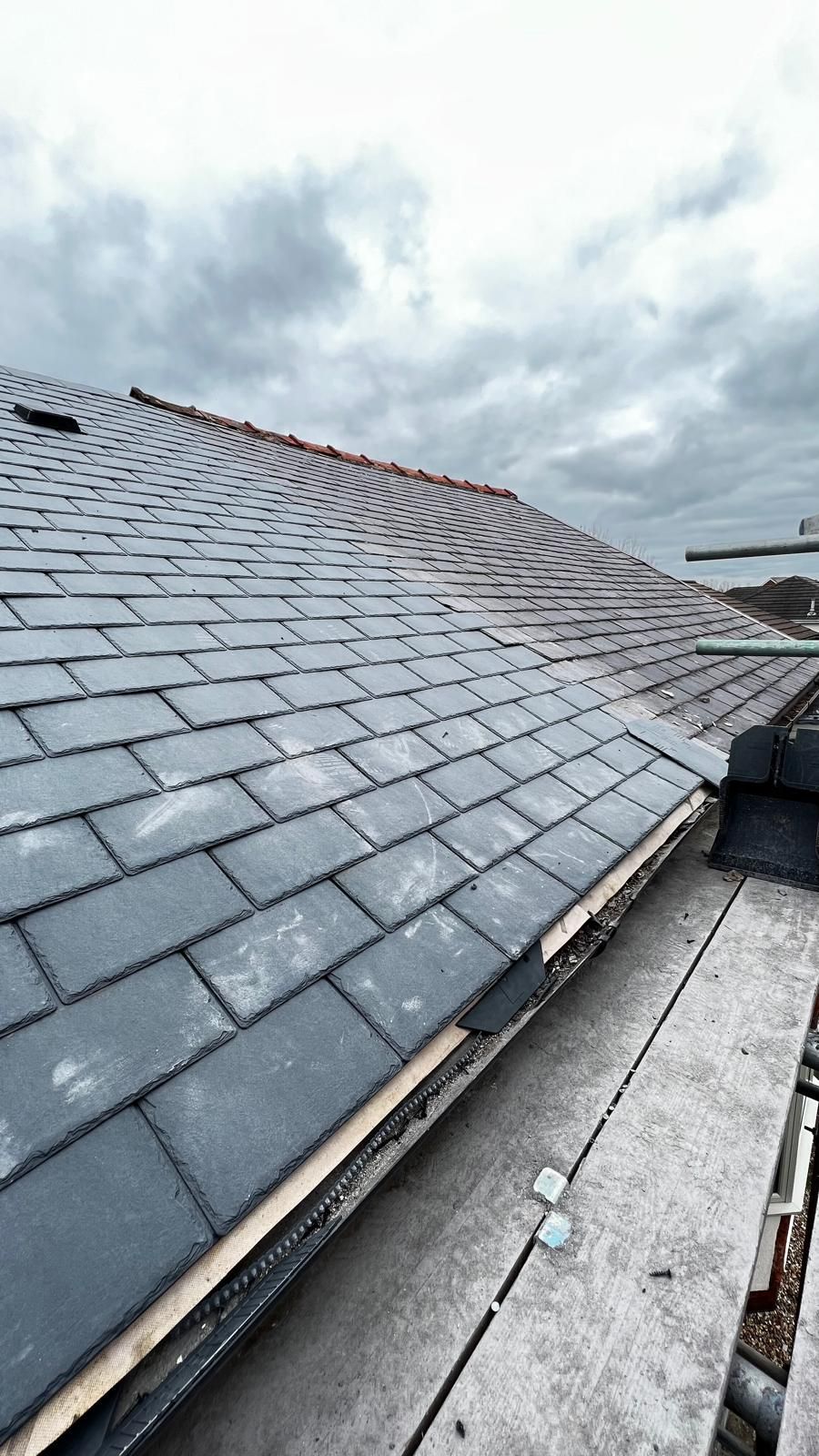 Dark gray slate roof under overcast sky.