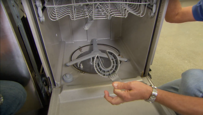 Appliance technician repairing a dishwasher