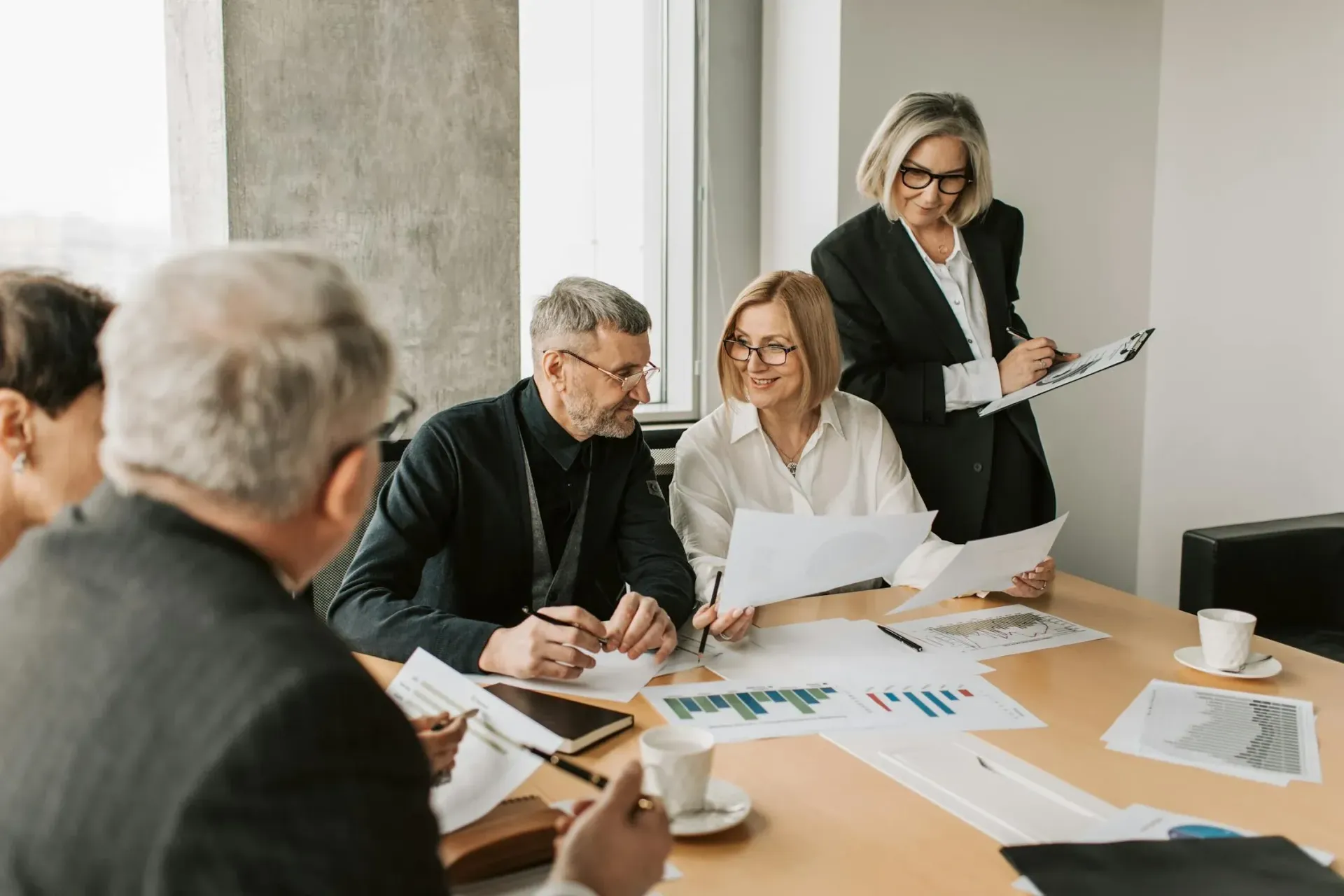 Professionals reviewing ESOP documents and financial charts in a modern office meeting.
