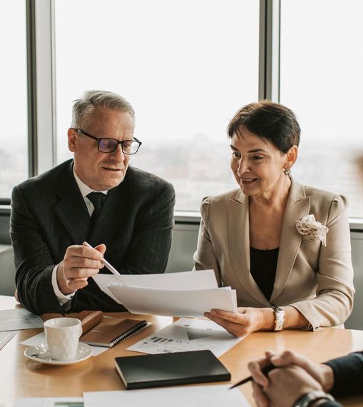 A man and a woman are sitting at a table looking at a piece of paper.