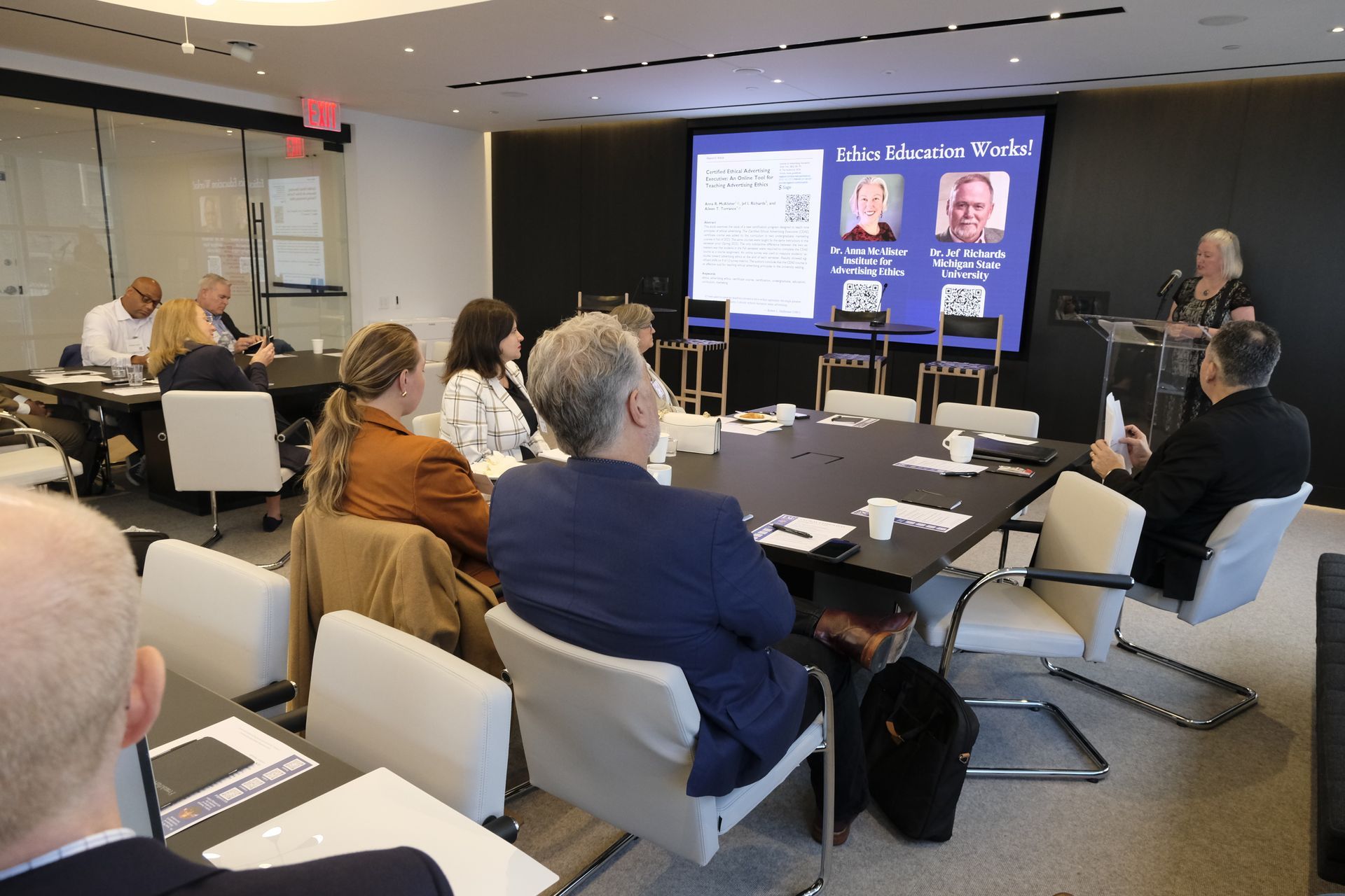 Zoomed out photo of Dr. Anna McAllister speaking to the crowd