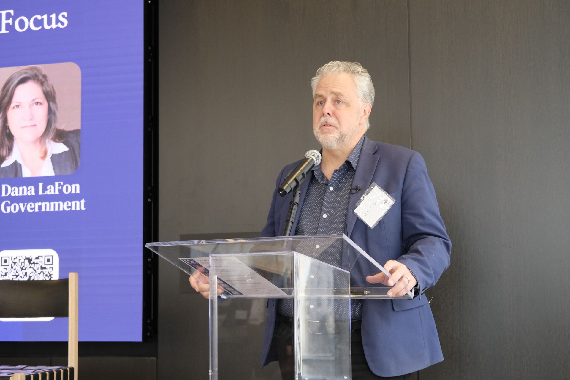 Photo of John C. Havens standing behind a podium speaking 