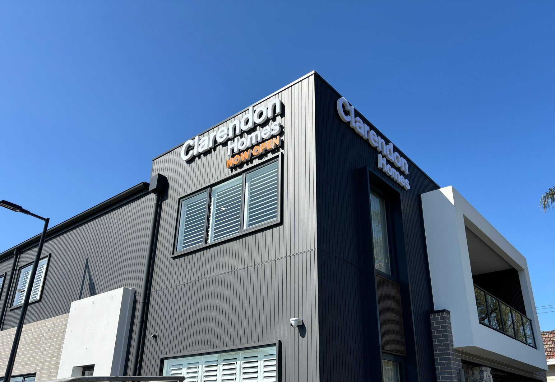 A large building with a lot of windows and a blue sky in the background.