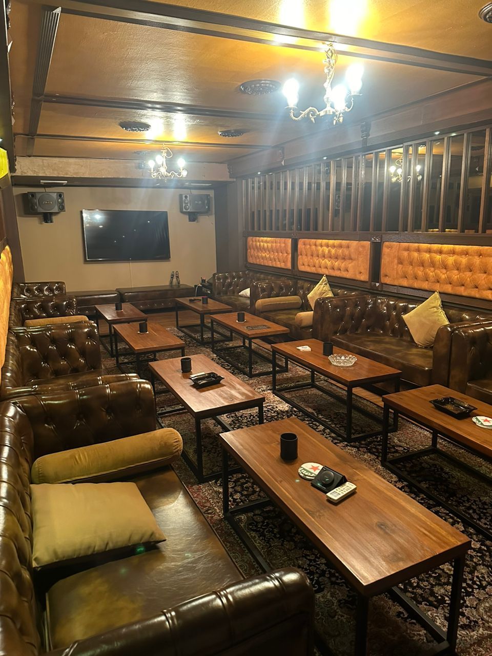 Cozy bar interior with leather booths, wooden tables, and dim lighting.