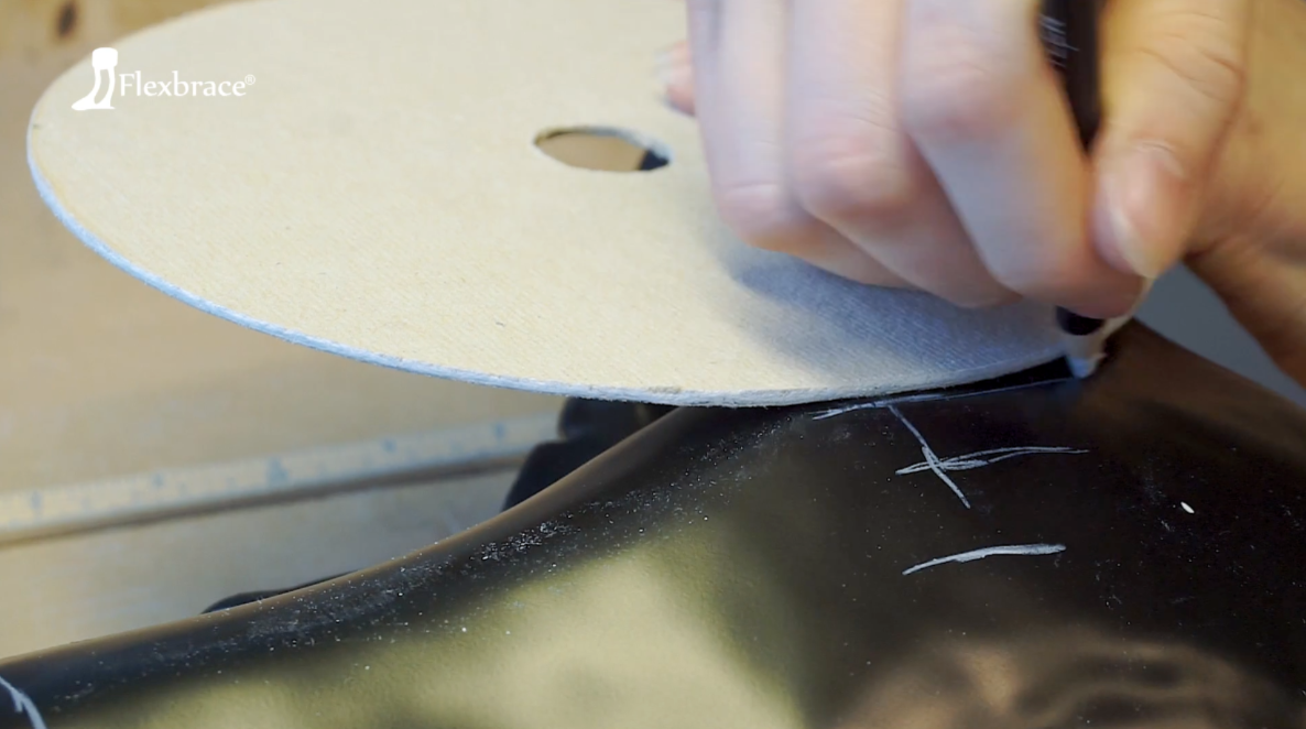 Sygeplejerske justerer en medicinsk støvle på en patients ben indendørs.