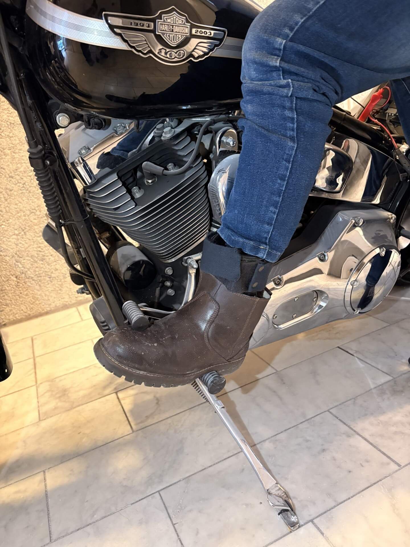 To ortopædiske ankel-fodortoser (AFO'er) med en sko, sort og hvid, mod en hvid baggrund.