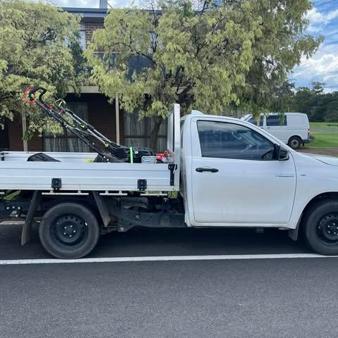 A White Ute With A Lawn Mower In The Back — RJT Lawn and Gardening in Leopold, VIC