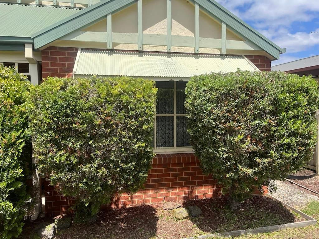 A White Truck is Parked in a Grassy Yard in Front of a House — RJT Lawn and Gardening in Drysdale, VIC