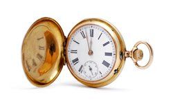 A gold pocket watch with roman numerals on a white background.