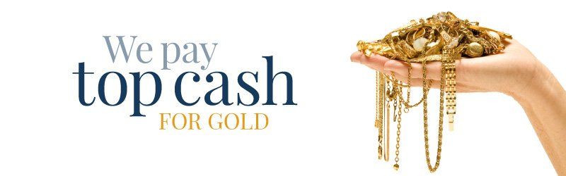 A person is holding a pile of gold jewelry in their hand.