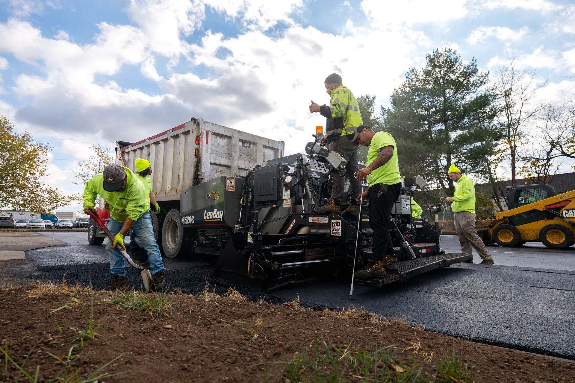 A group of construction workers are working on a road.