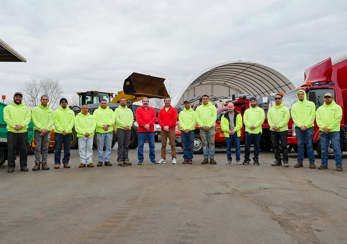 A group of men are posing for a picture in a parking lot