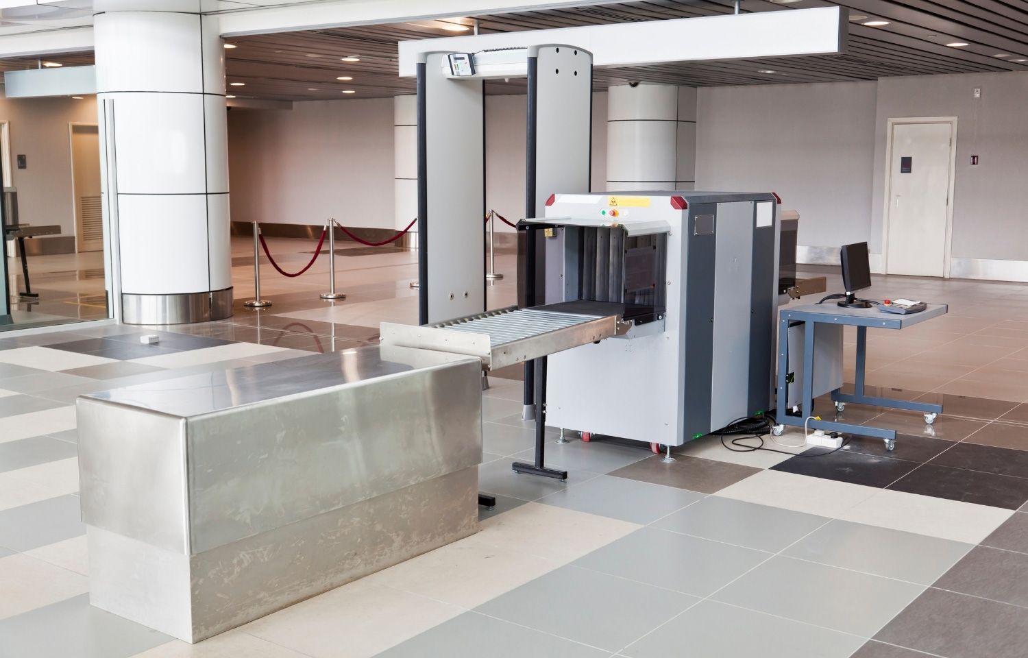 Security checkpoint with a metal detector Security checkpoint with baggage scanner, metal detector, and conveyor belt, in a brightly lit building.