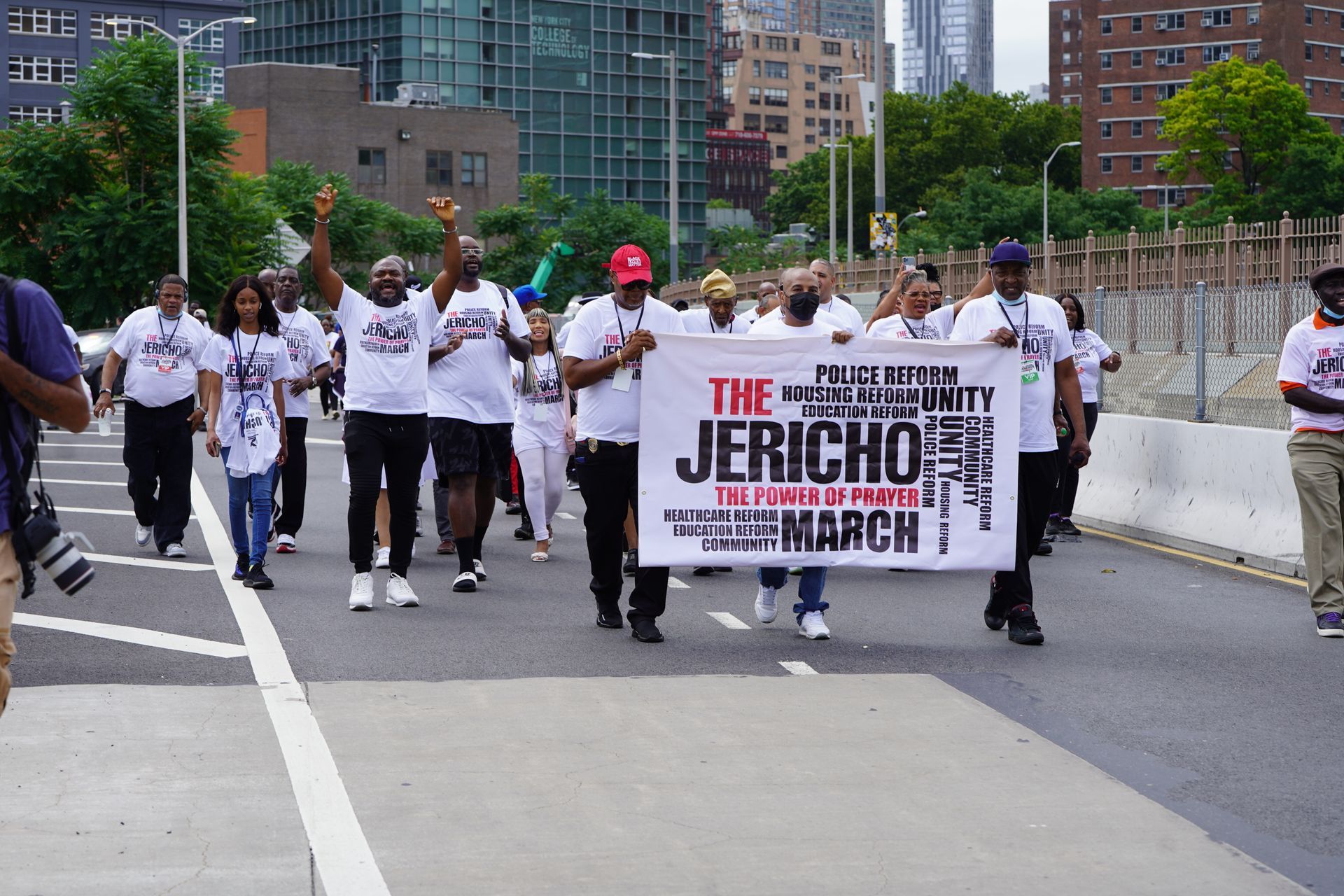 A group of people marching down a street holding a sign that says the jericho march