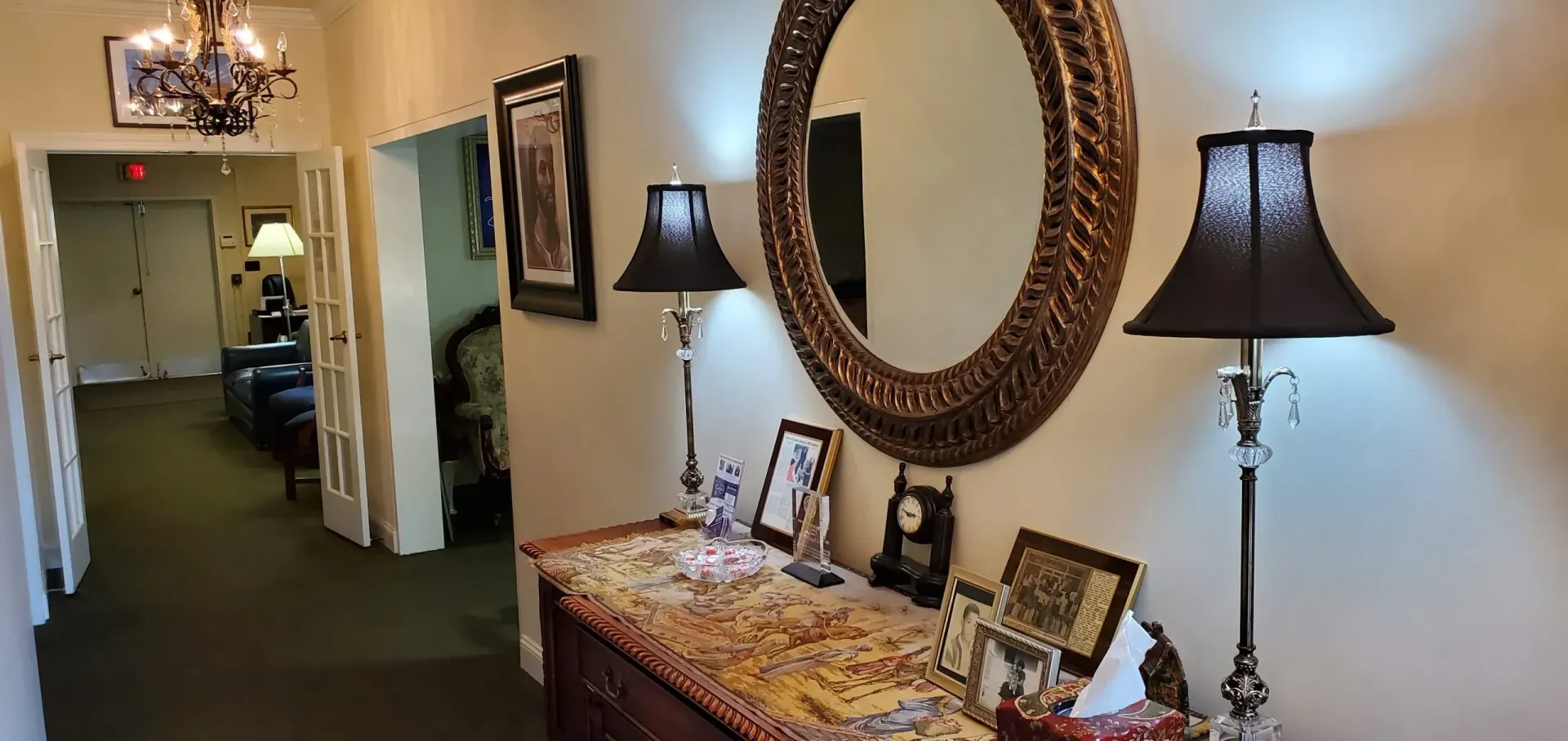 Hallway with a decorative table, large mirror, and lamps.