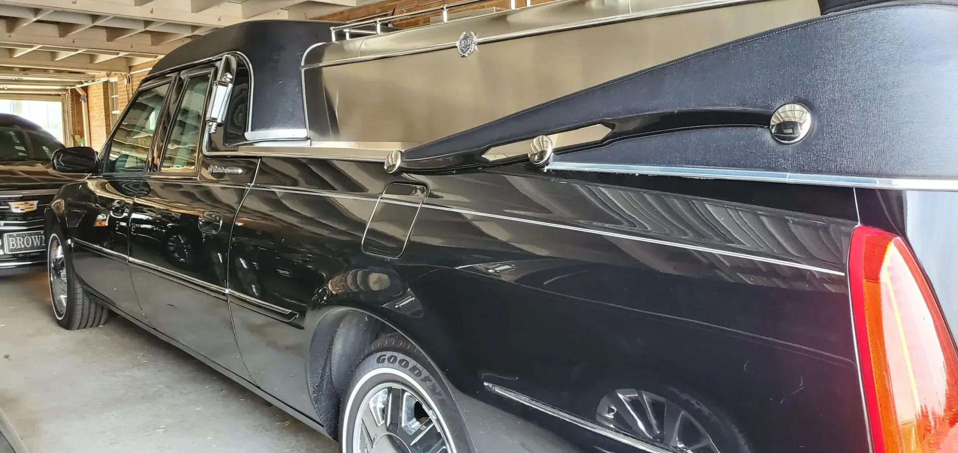 Black hearse parked in a garage.
