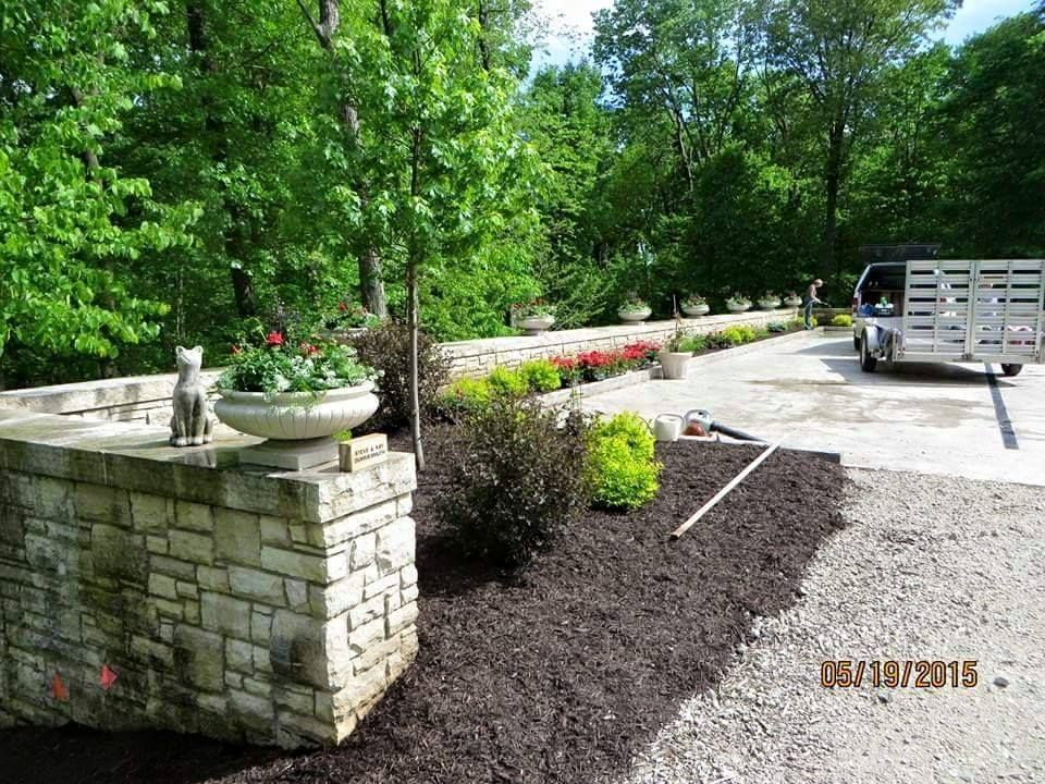A truck is parked in a driveway next to a stone wall.