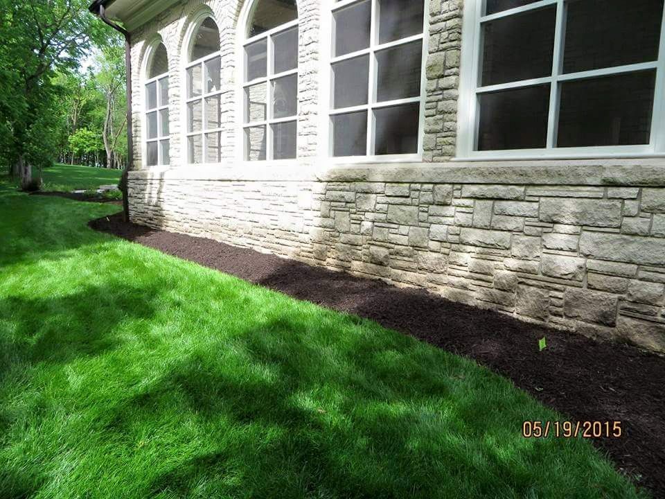 A house with a screened in porch and a lush green lawn in front of it.