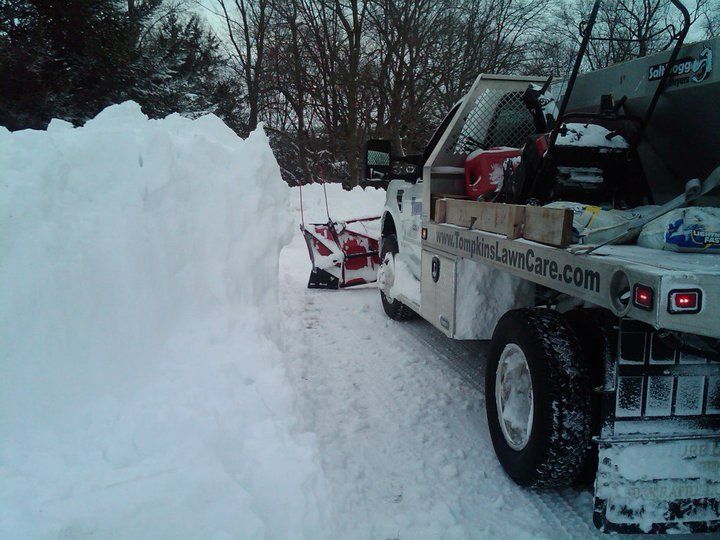 A snow plow is on the back of a white truck