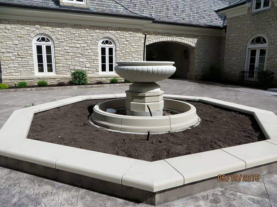 A fountain in front of a large stone building