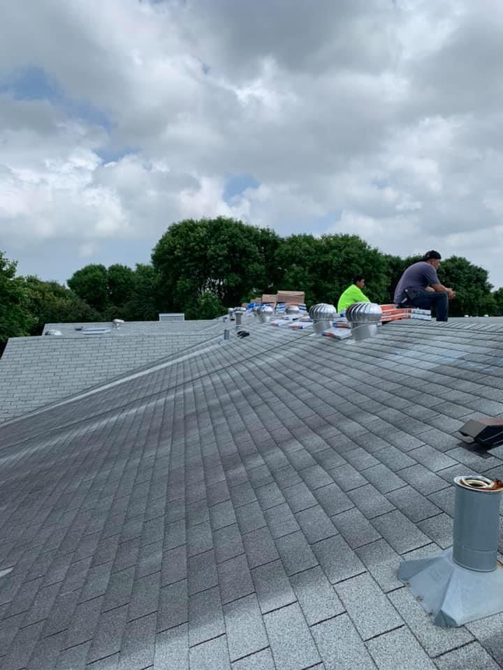 Two men are working on the roof of a building.