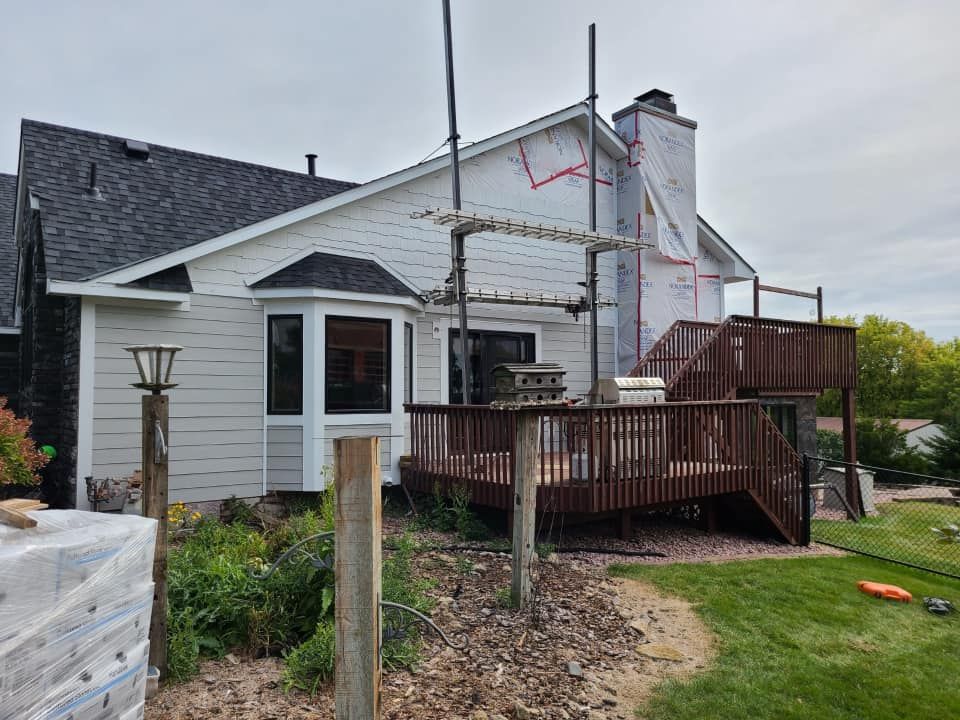 A house with a deck and scaffolding in front of it.