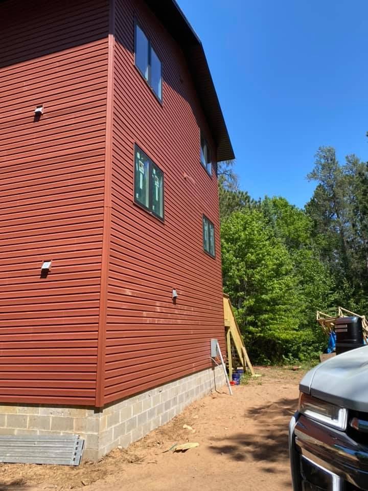 A large red house with a truck parked in front of it.