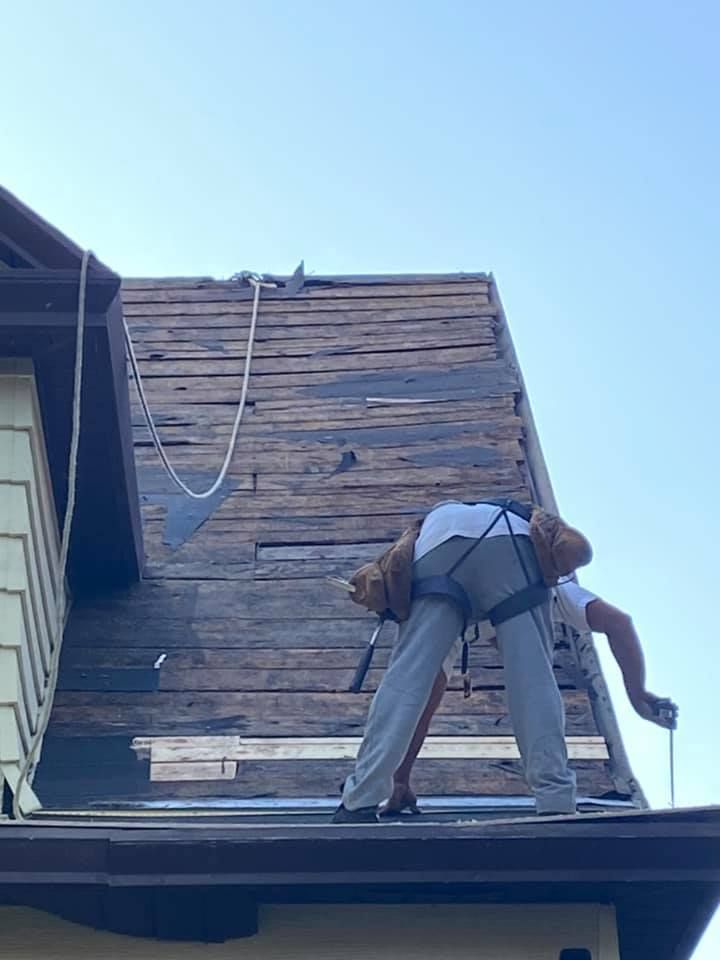 A man is working on the roof of a house.