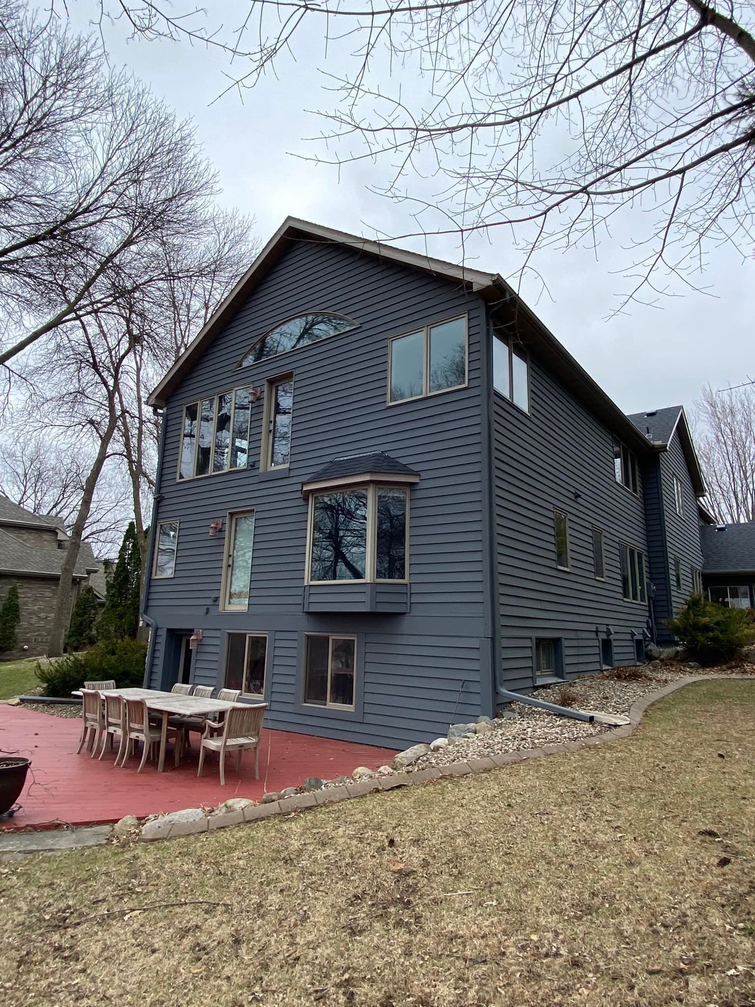 A large house with a patio and a table and chairs in front of it.