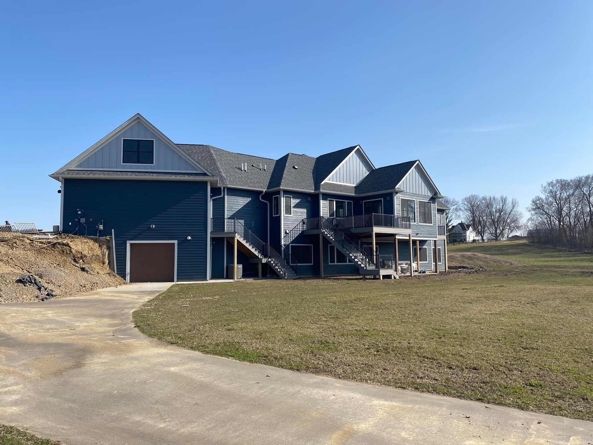 A large house is sitting in the middle of a grassy field.