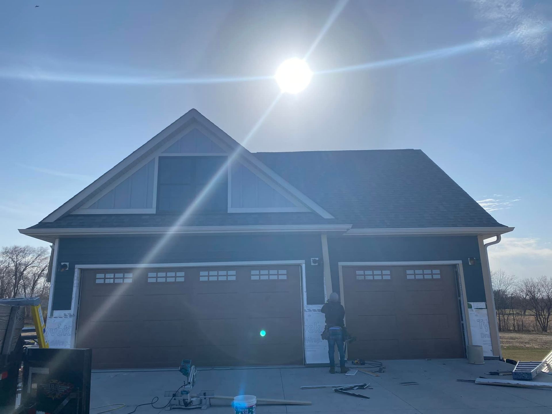 A man is standing in front of a house that is being built.
