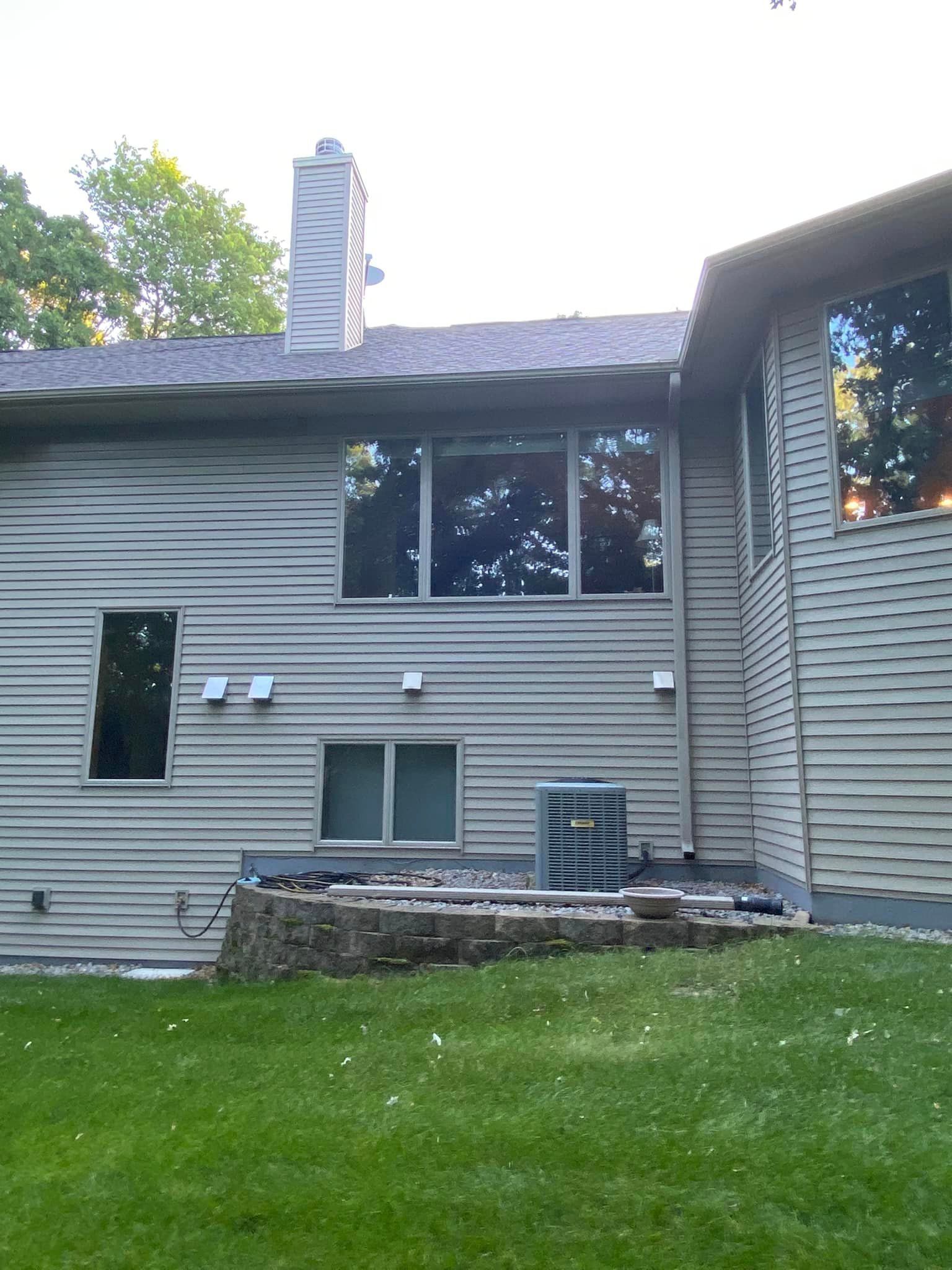 The back of a house with a lot of windows and a chimney.