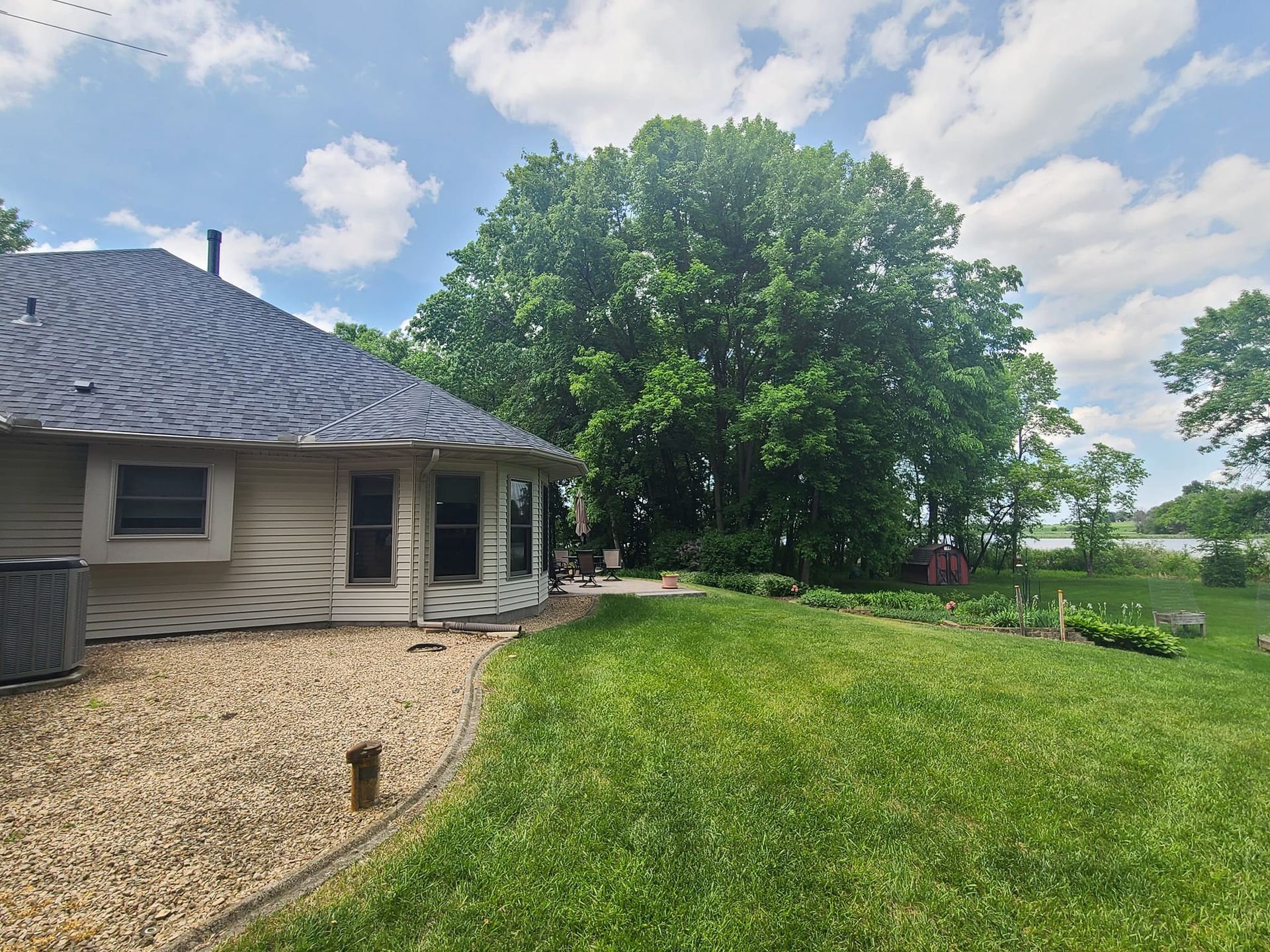 A house with a lot of grass and trees in front of it