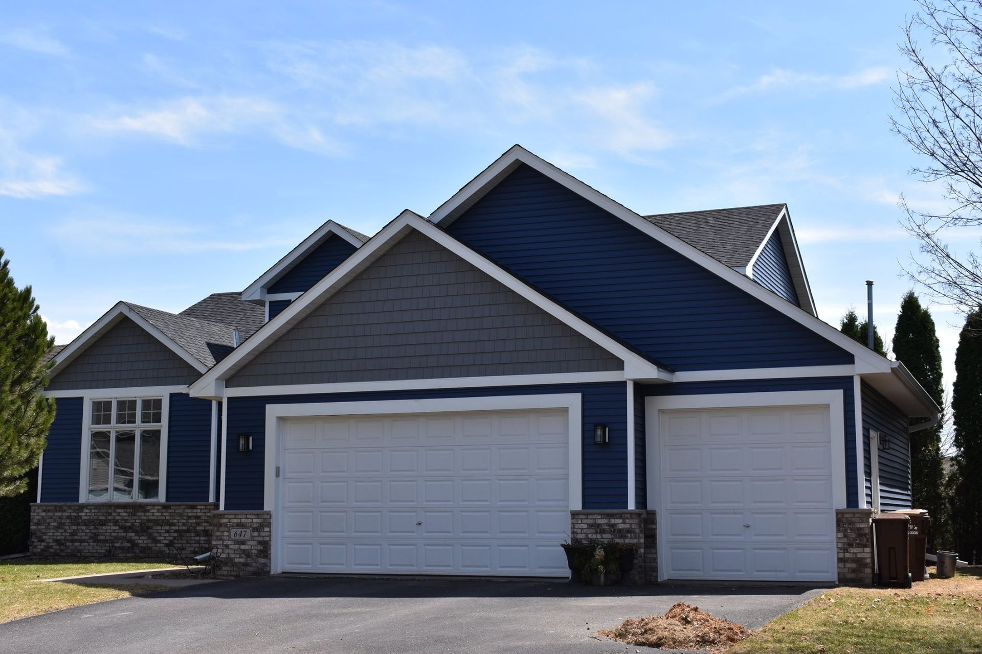 A house with blue siding and white garage doors