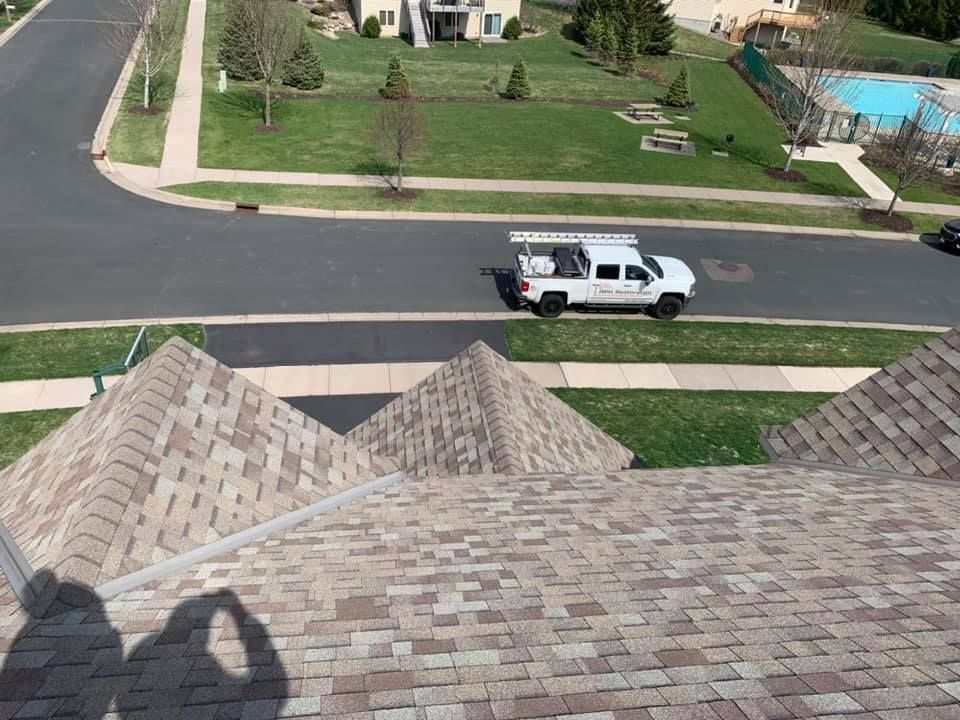 A white truck is parked on the roof of a house.